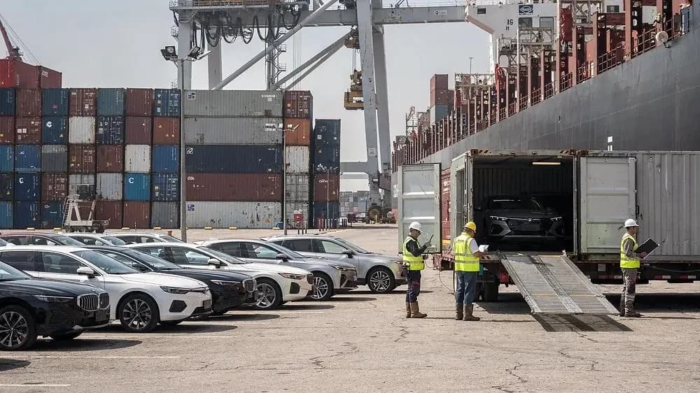 Vehicles being loaded into a shipping container at the port